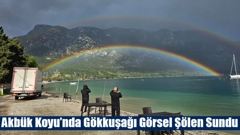Akbük Koyu’nda yağmurun ardından ortaya çıkan gökkuşağı, sahilde bulunan vatandaşlar
